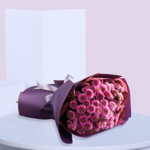 A large bouquet of pink chrysanthemums wrapped in purple paper with a white ribbon.