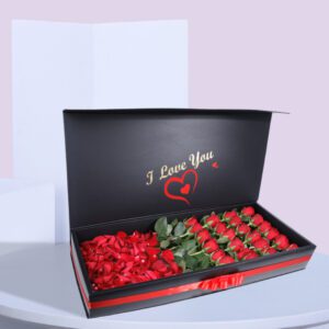 A black gift box open to reveal a compartment of red roses and another compartment of red rose petals. The lid of the box has the words "I Love You" printed on it.