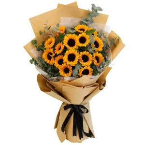 A bouquet of sunflowers wrapped in brown paper with a black ribbon.